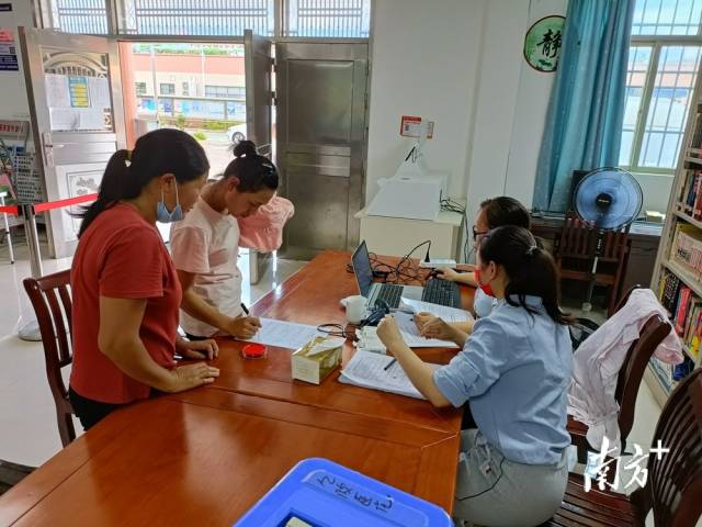 鎮(zhèn)、村干部為村民進(jìn)行接種信息錄入。