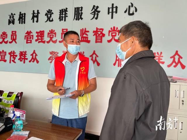 正在為群眾辦事的沈家江（左）。