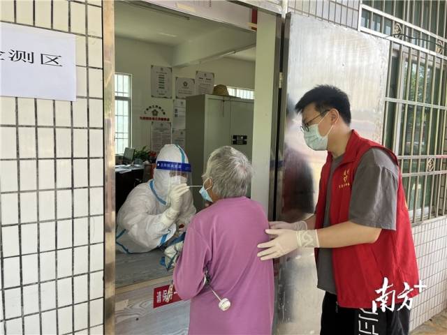現(xiàn)場(chǎng)志愿者幫助行動(dòng)不便群眾接受核酸檢測(cè)。