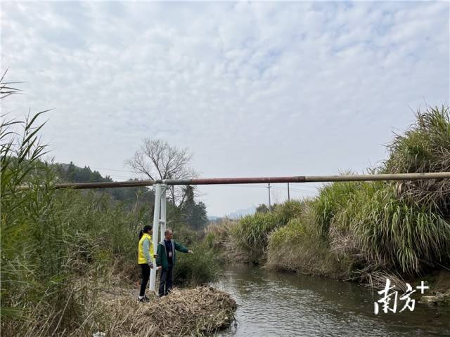 余榮華與戴海玲查看水渠建設(shè)情況。